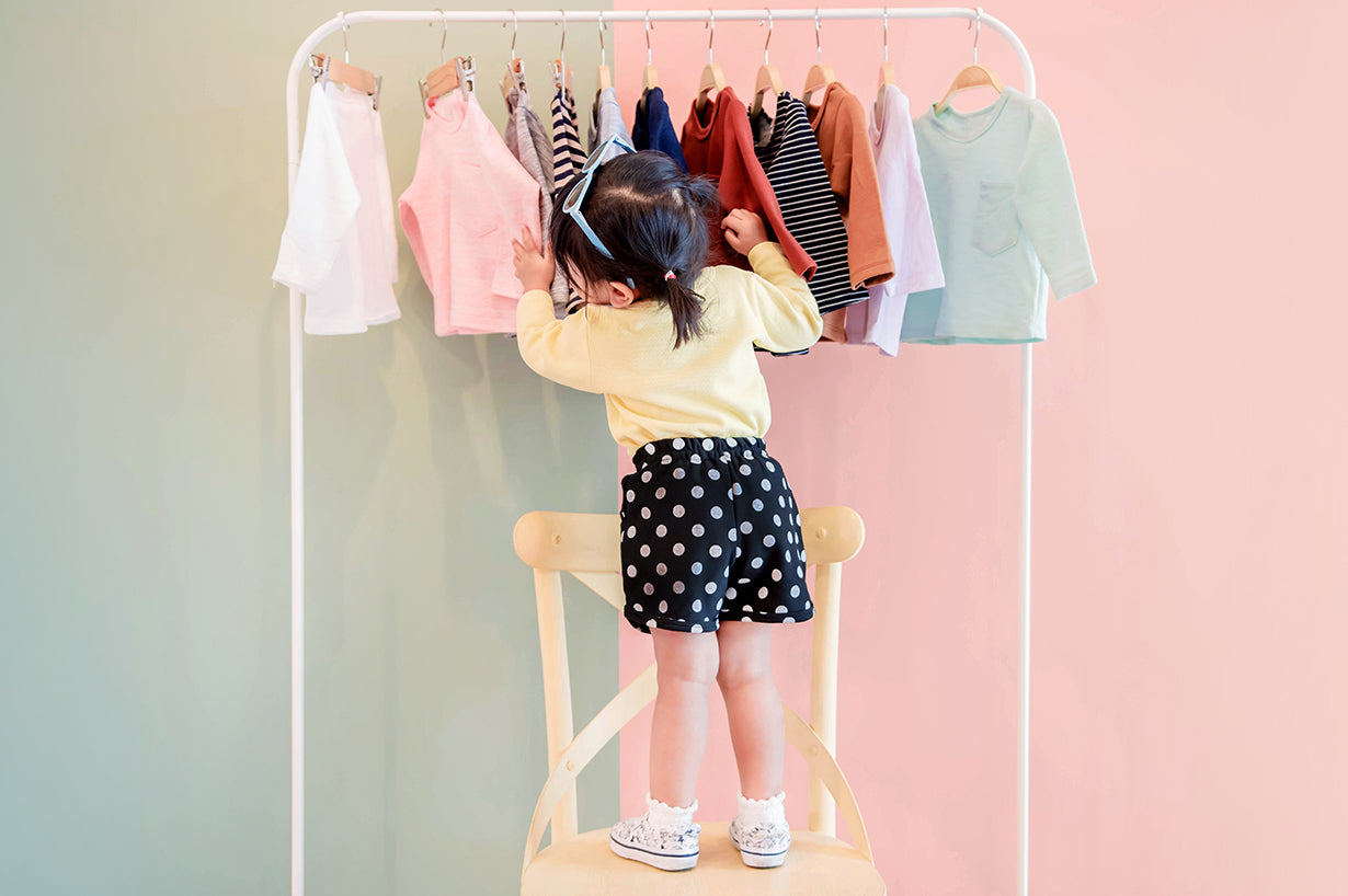 A cute baby choosing a dress